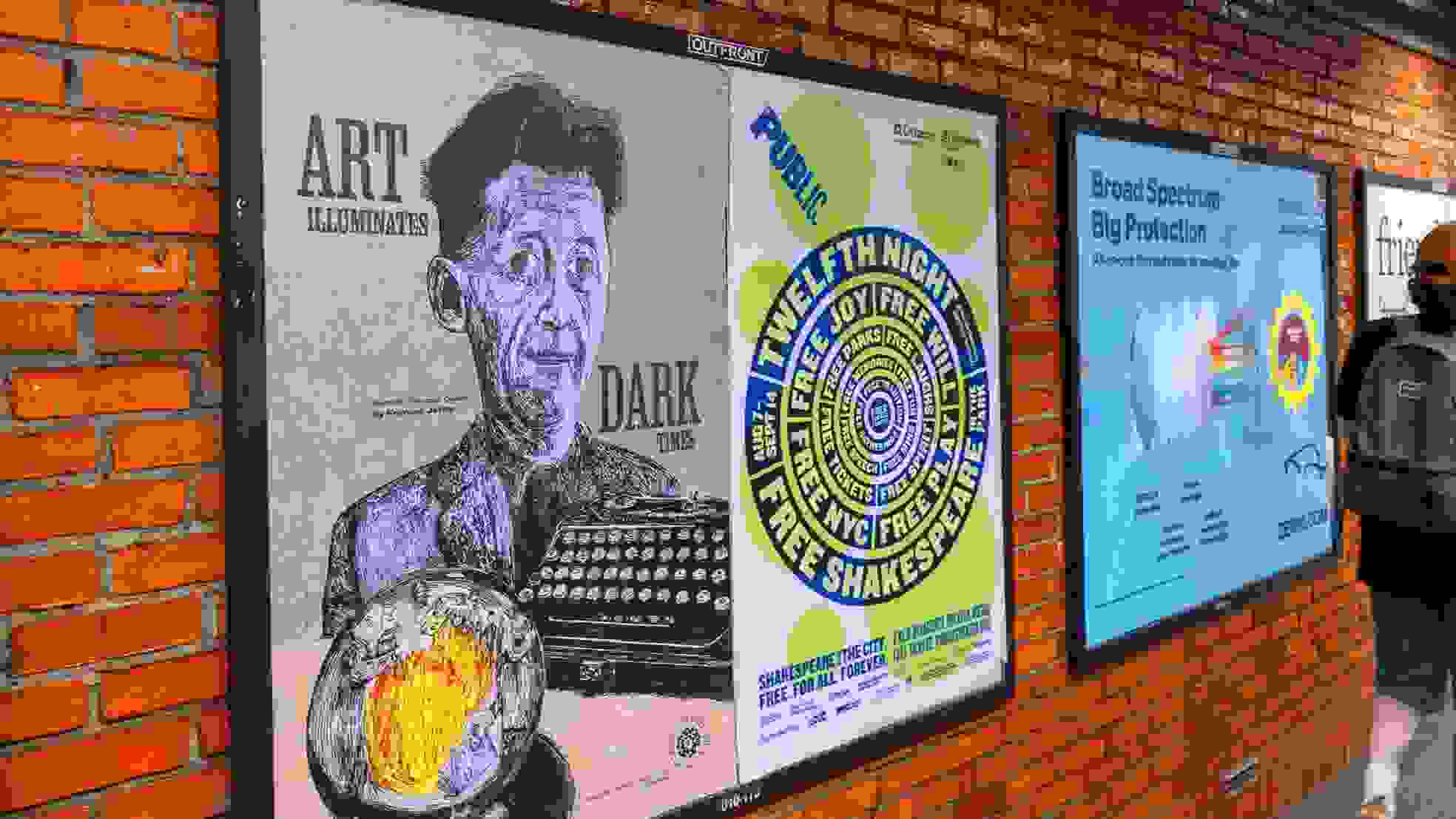 A man strolls past a brick wall adorned with vibrant posters.