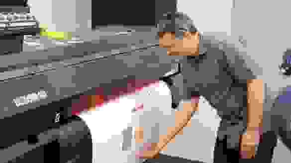 Instructor waiting as a color printer produces a very large sheet.