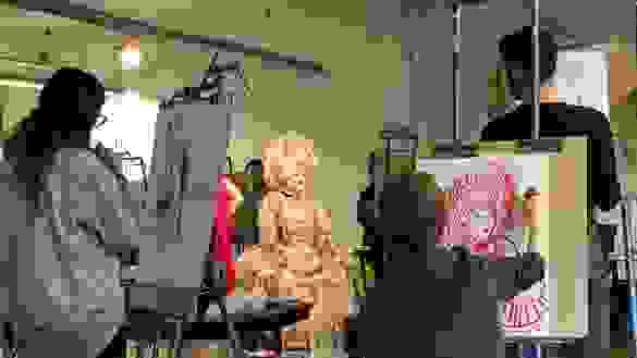 Woman drawing a model with easles