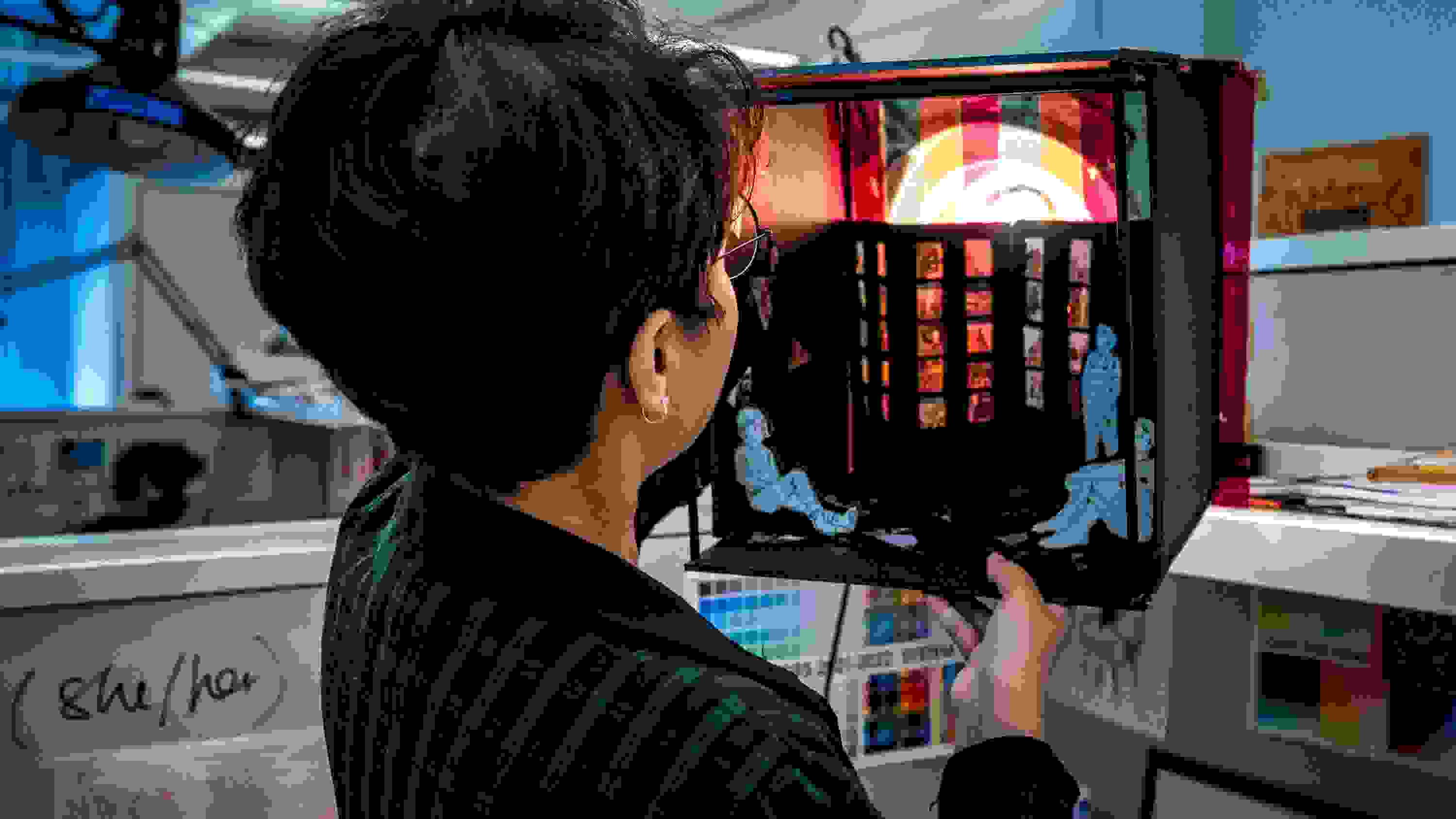 Photo of person holding a box containing a diorama that is illuminated, in the studio of MFA Visual Narrative's summer studio's