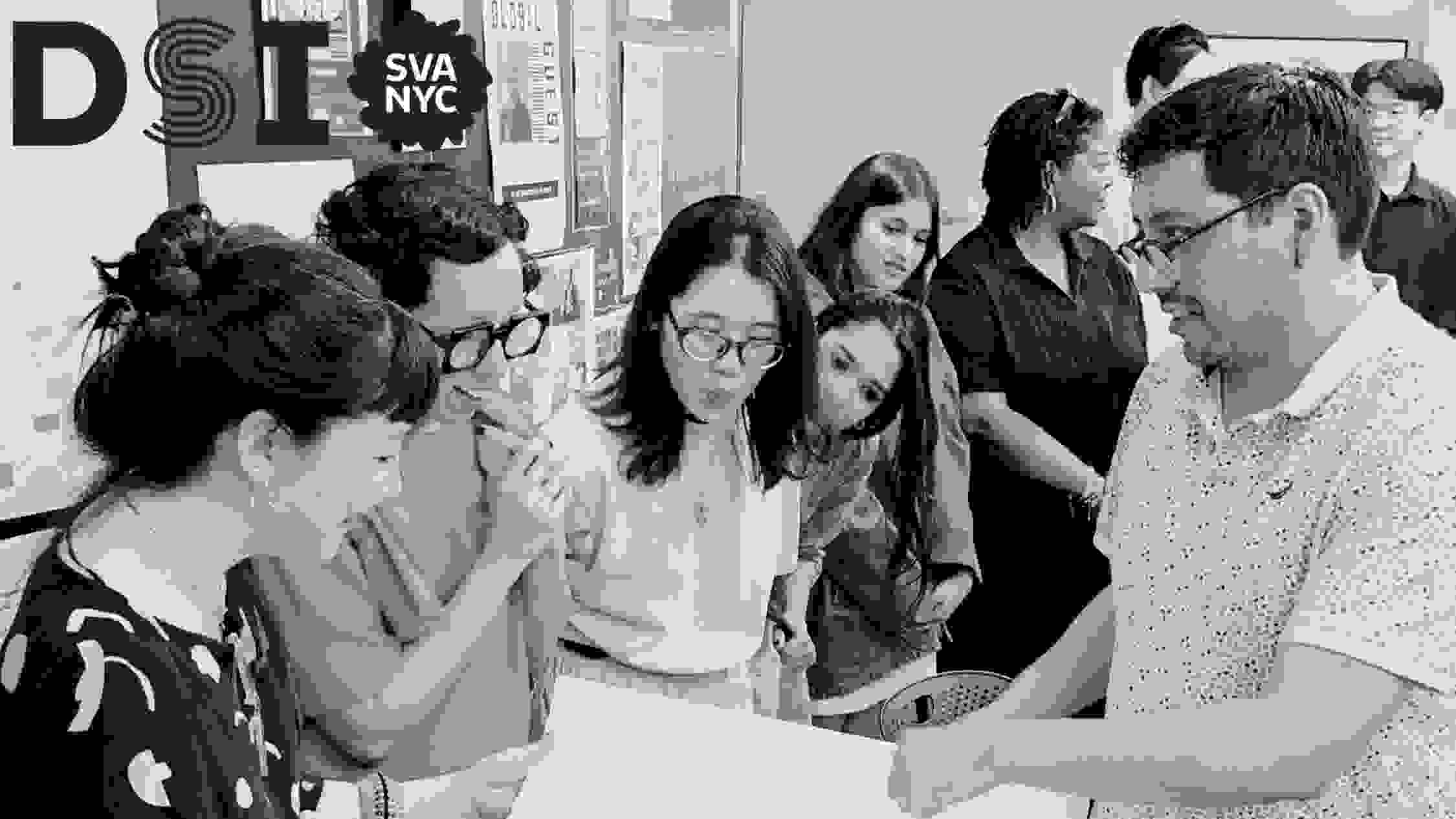 Black and white photo of students with instructors looking at a poster in the middle
