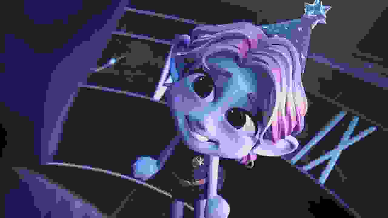 Small, purple, elf-like figure wearing a party hat has a chipper expression while smiling at an obscured figure in the foreground.