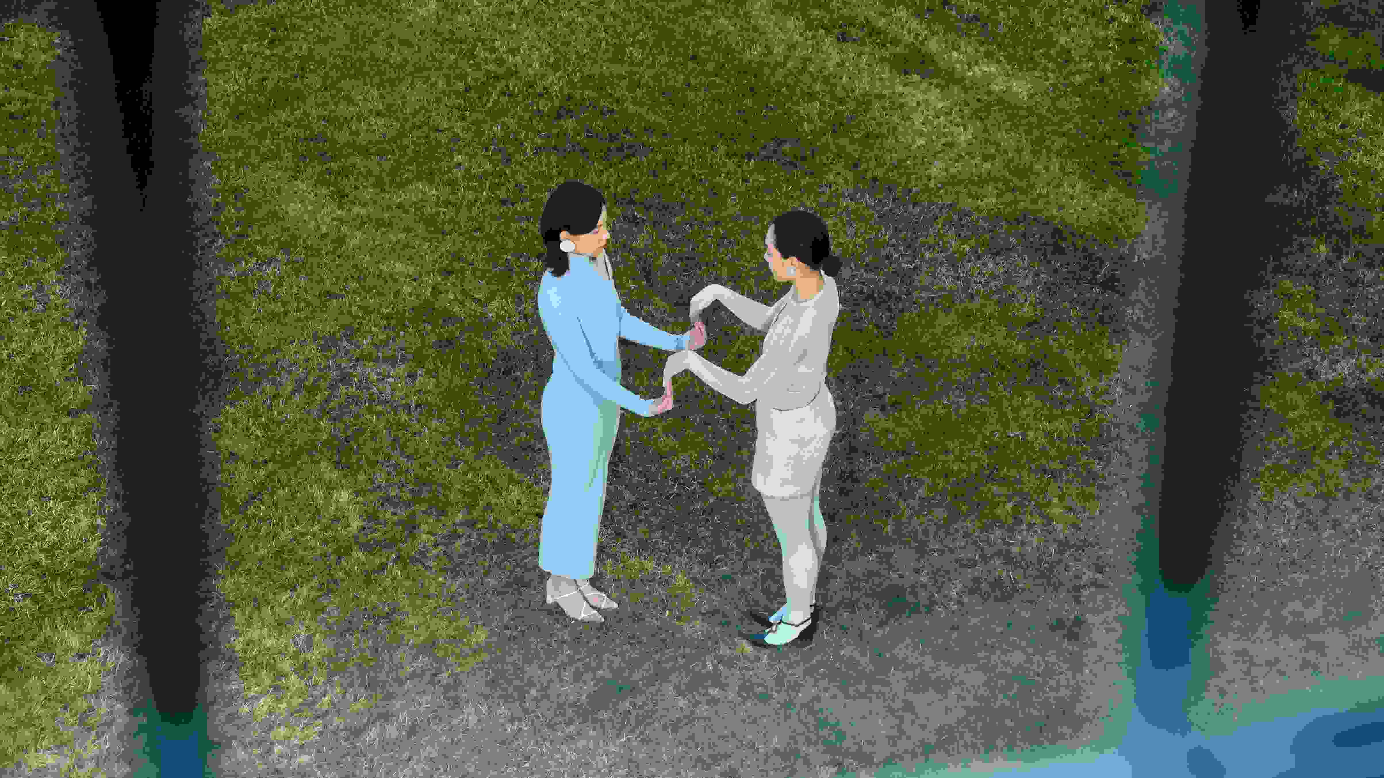 Birds eye view of Two people playing a hand clap game; the grass beneath their feet is very green.