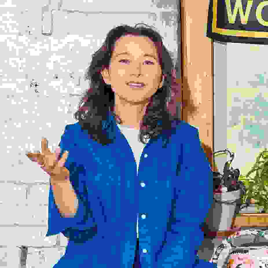 Photo of woman in blue shirt gesturing to camera