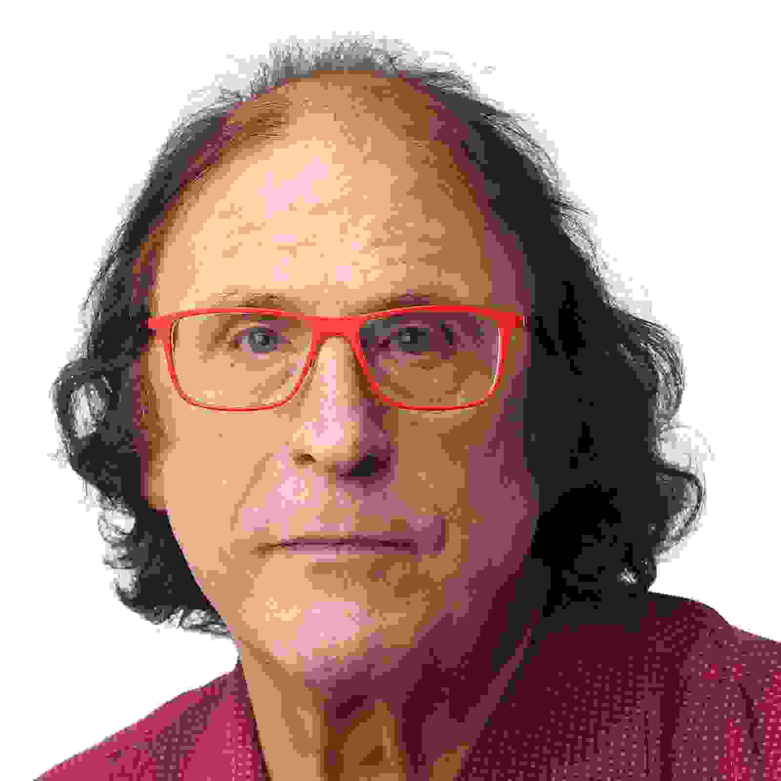 A portrait of Jim Estrin, who is wearing a pair of glasses with a red frame, and a red shirt with white polka dots. 