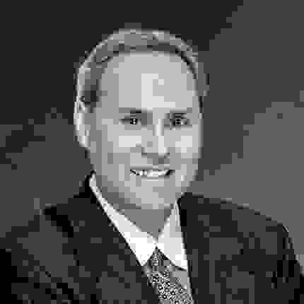 person in a suit, smiling at the camera