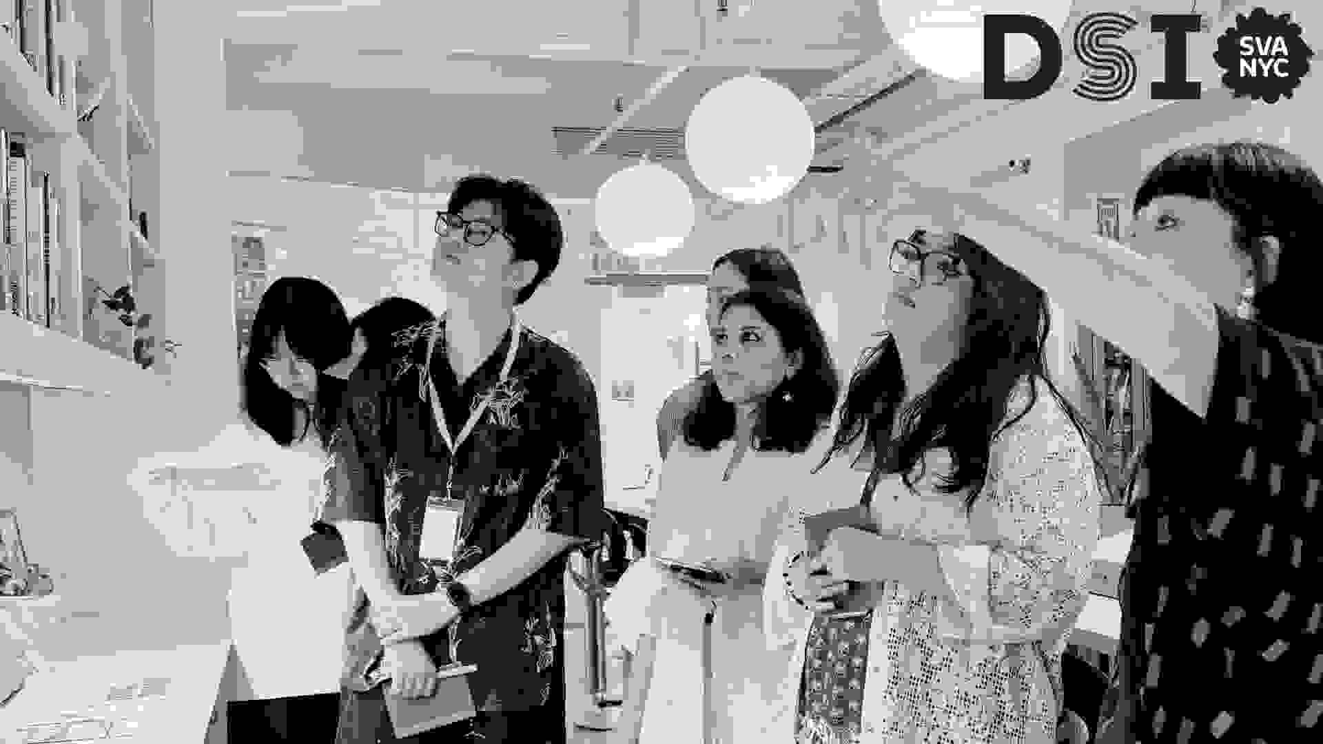Students looking up at library with instructor pointing