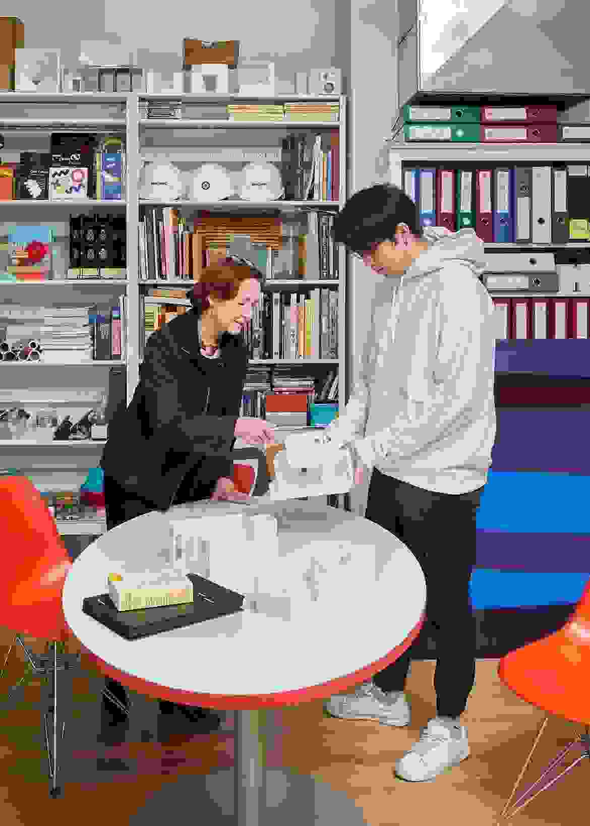 A teacher and student in an educational setting examine a 3D printed mini model