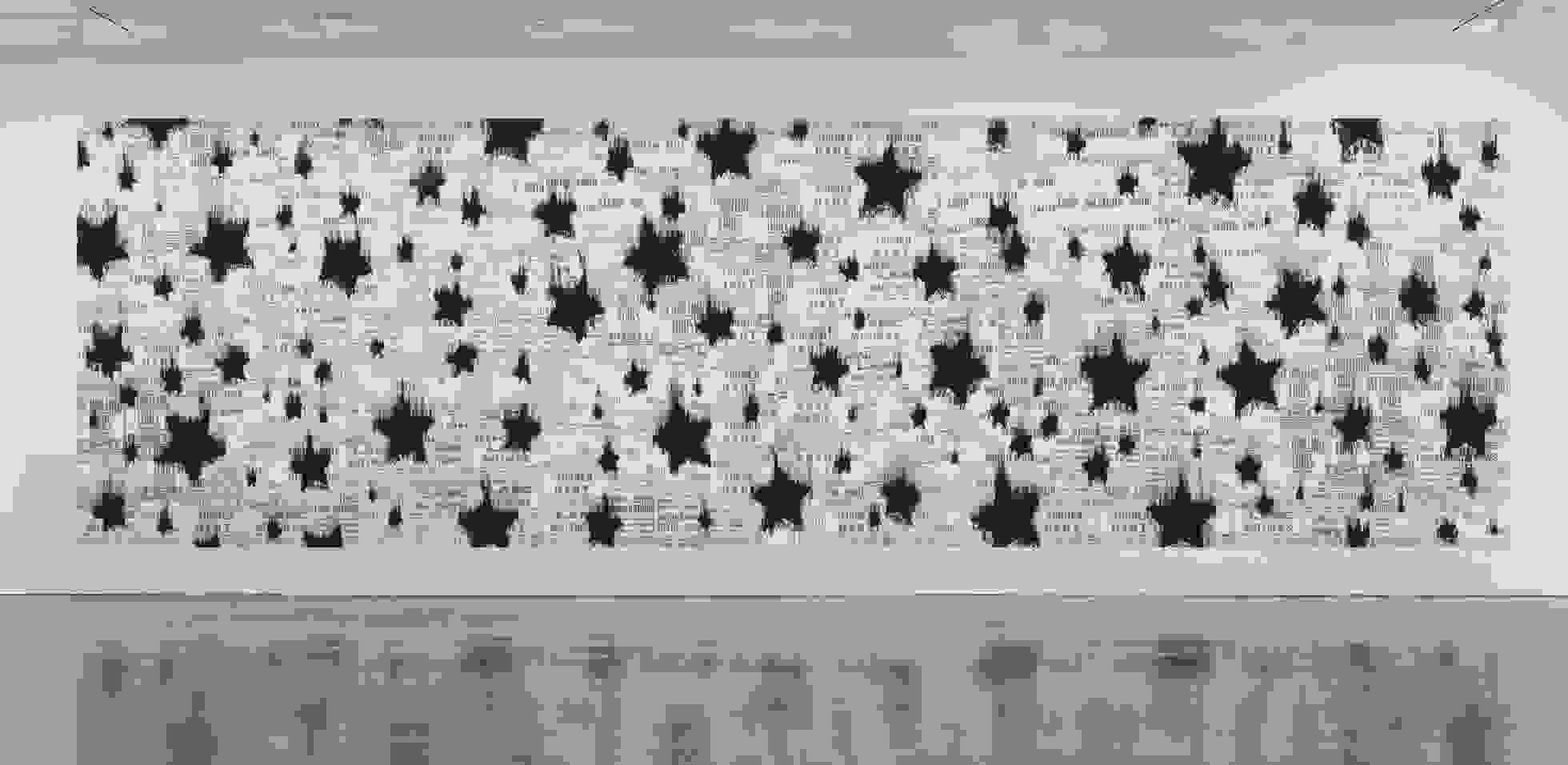 <p "="">A large monochrome mural consisting of black stars painted over a collage of boxing-poster reproductions.