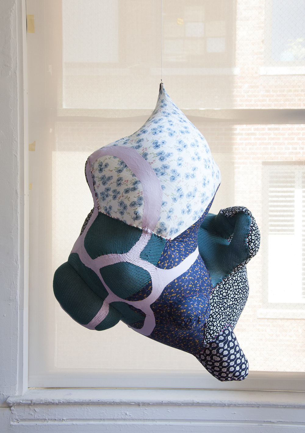 <p "="">An abstract, hanging sculpture made of stitched-together secondhand fabrics.