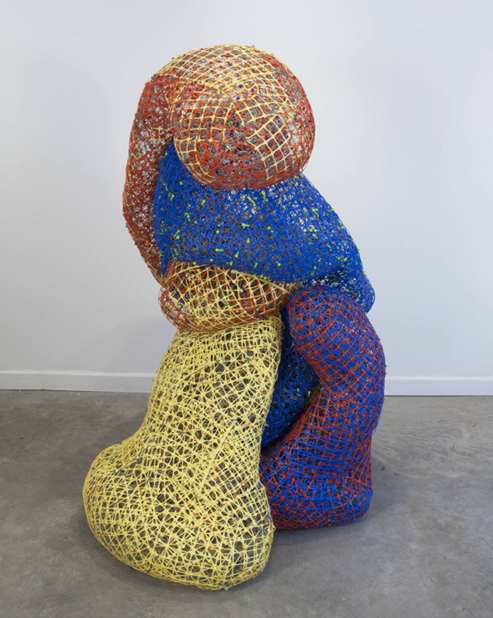 <p "="">An abstract sculpture made of several masses of differently colored fence materials.