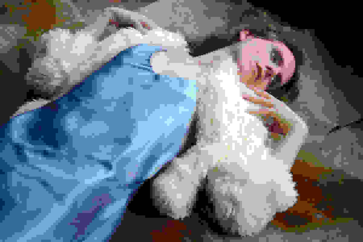 <p "="">A photograph of a person lying on the floor, wearing a blue slip dress and white jacket.