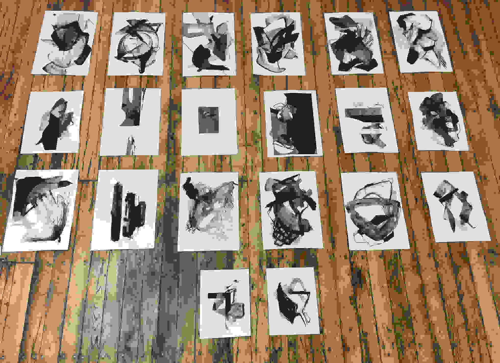 Index cards with abstract images lying on a wooden floor.