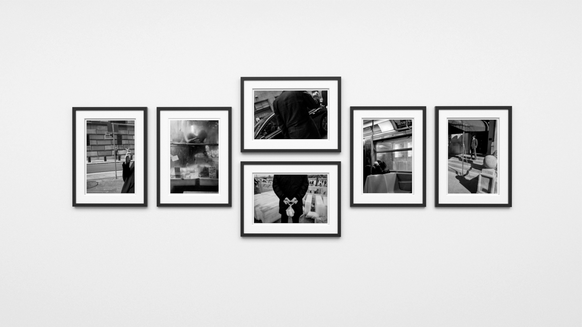 Black and white photographs in black frames with white mats.