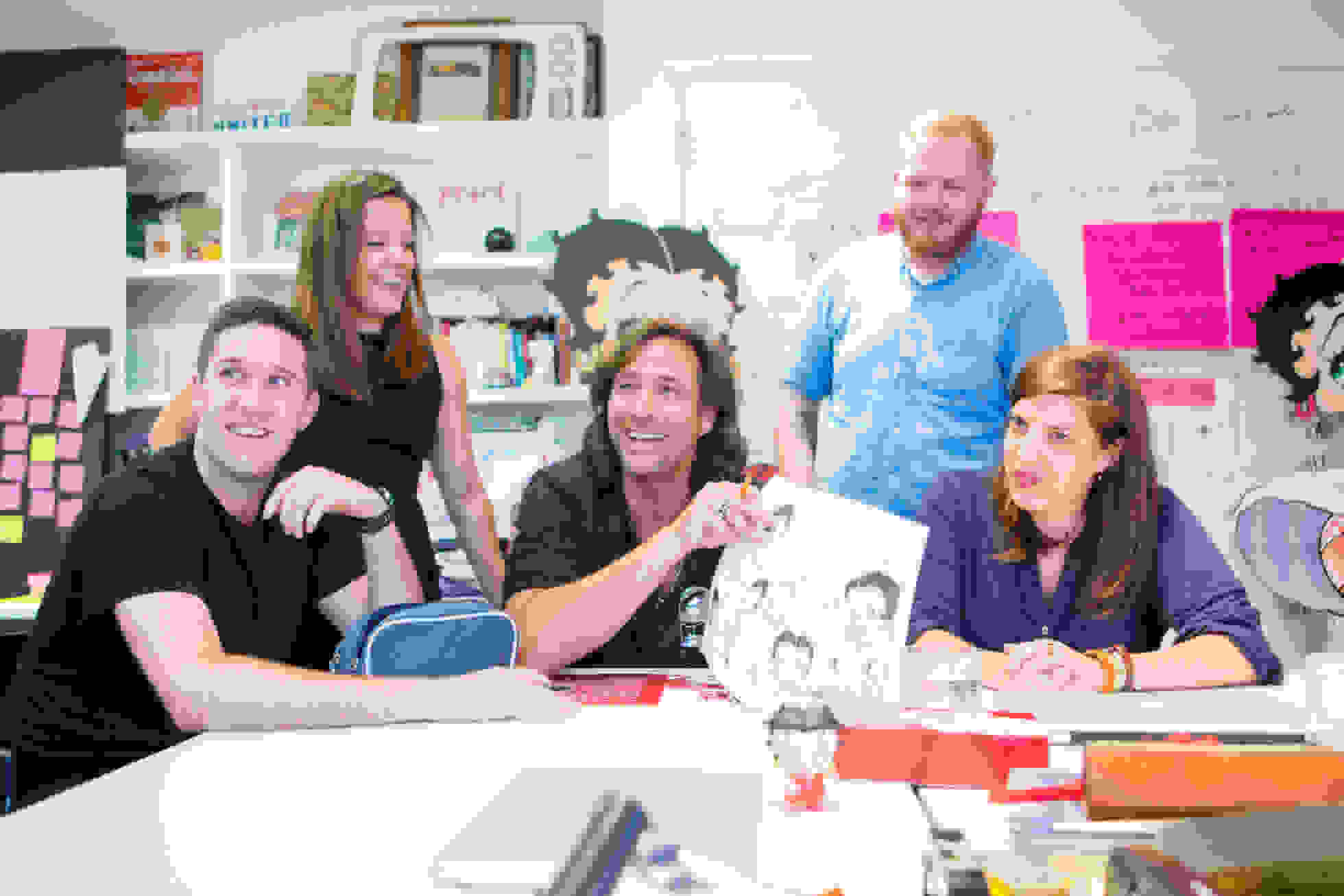 Different people working on a comic and laughing