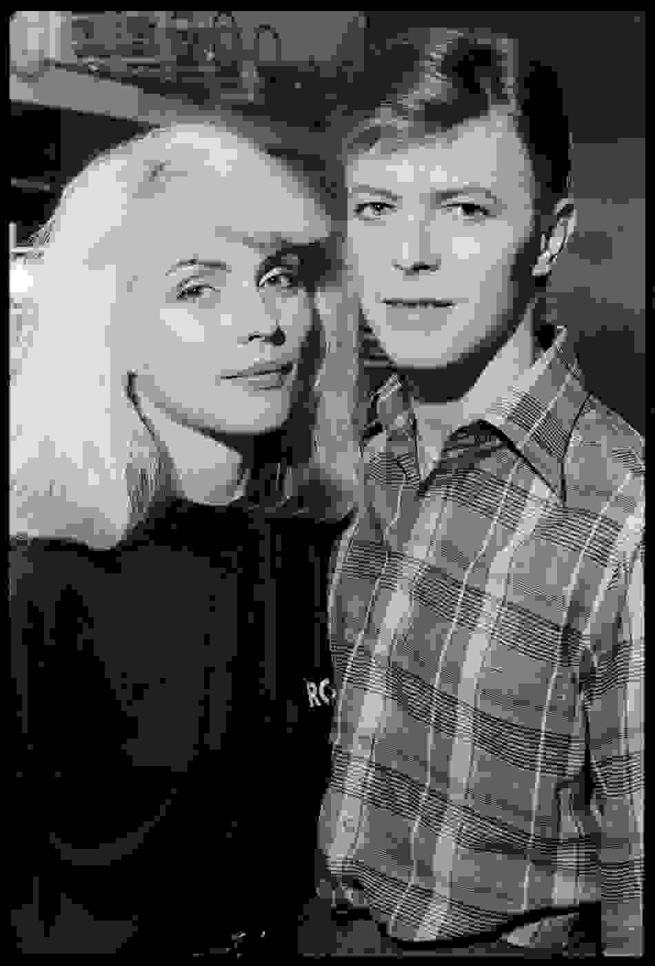 A black-and-white photo of a woman in a black shirt and a man in a button-front plaid shirt.