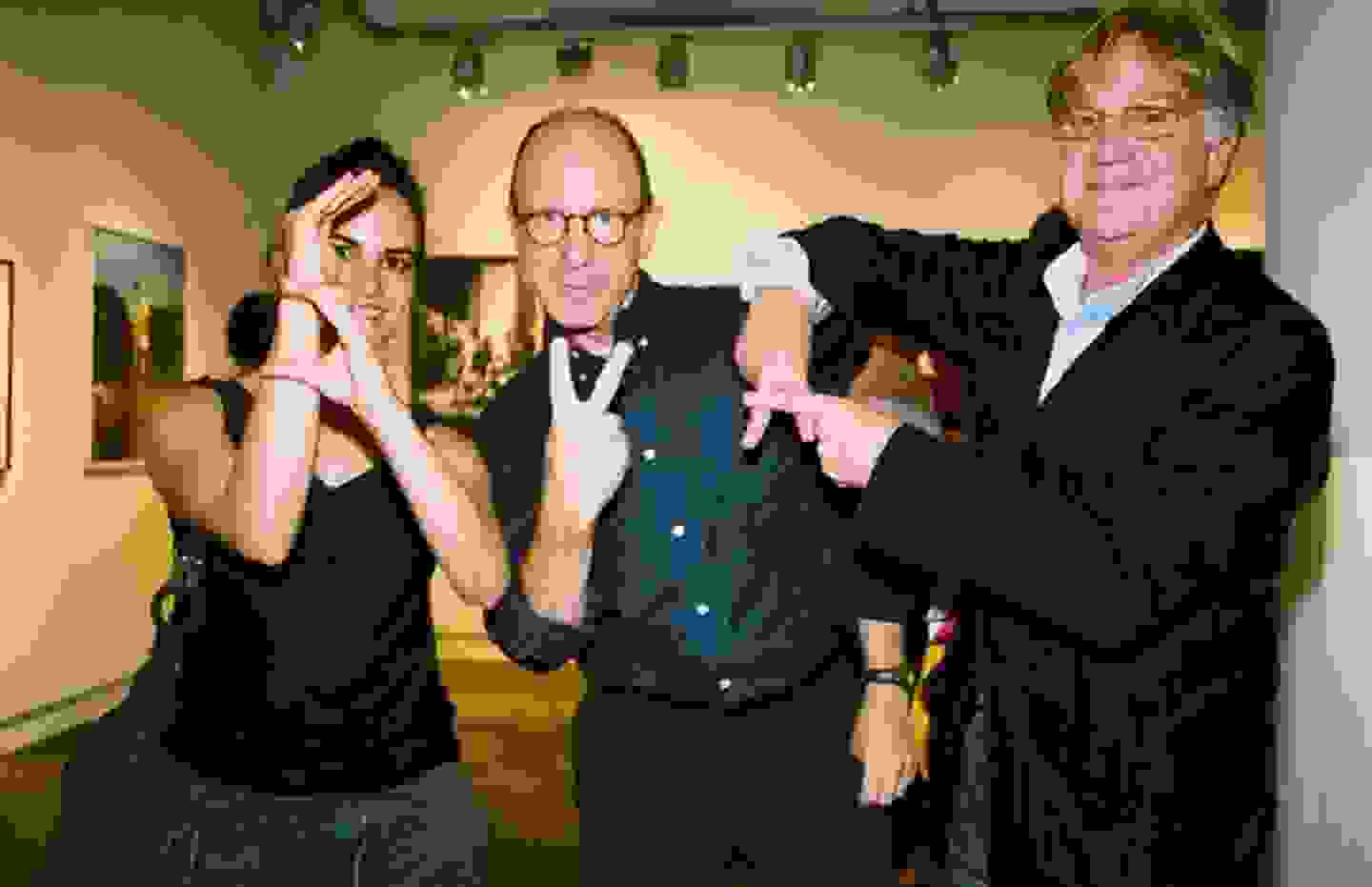 Three people spell out S V A with hand gestures