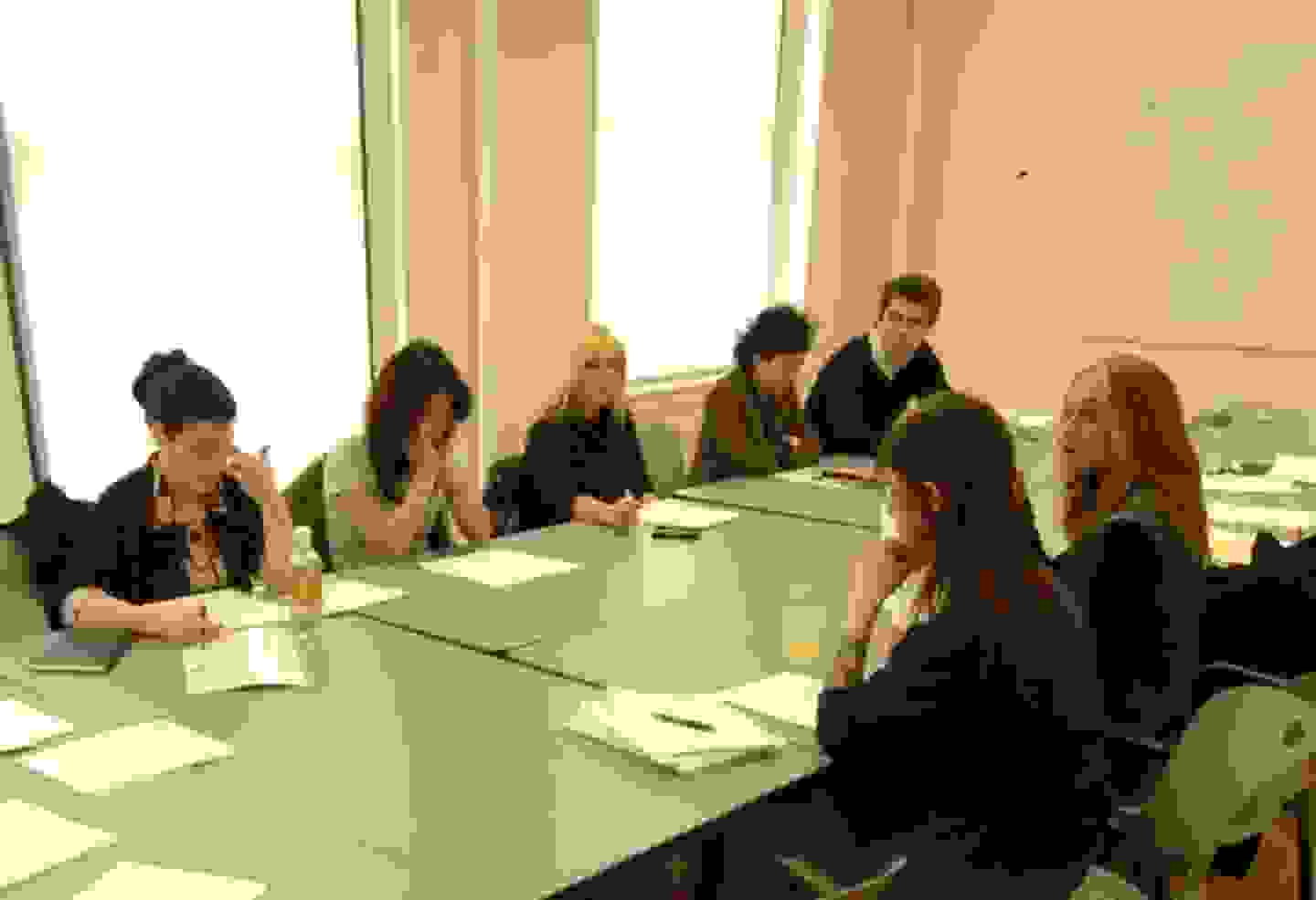 People gathered around a conference table, maybe working on a group project