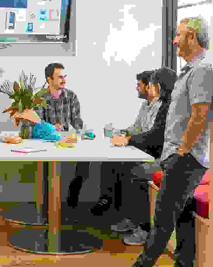 People congregating in an open plan, community oriented lounge.