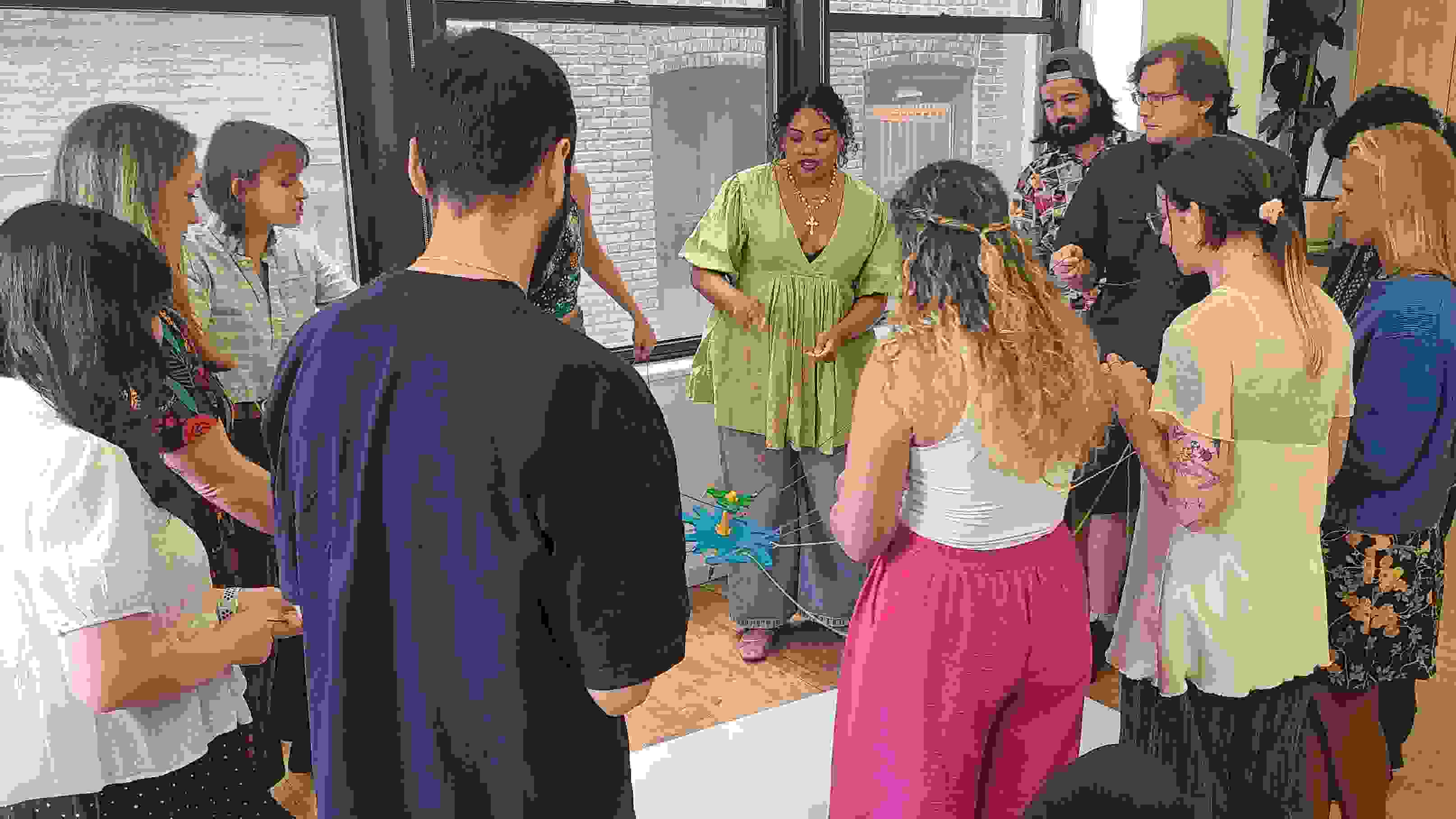Students working together with string to control a pen over paper.