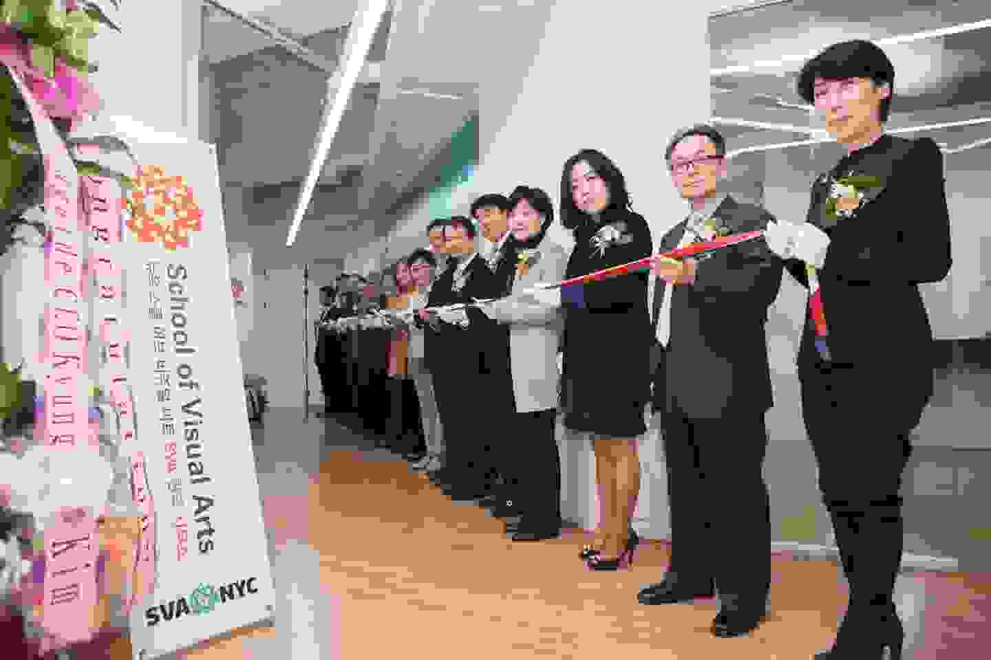 Many people holding a long ribbon for a ribbon cutting event at SVA in Seoul