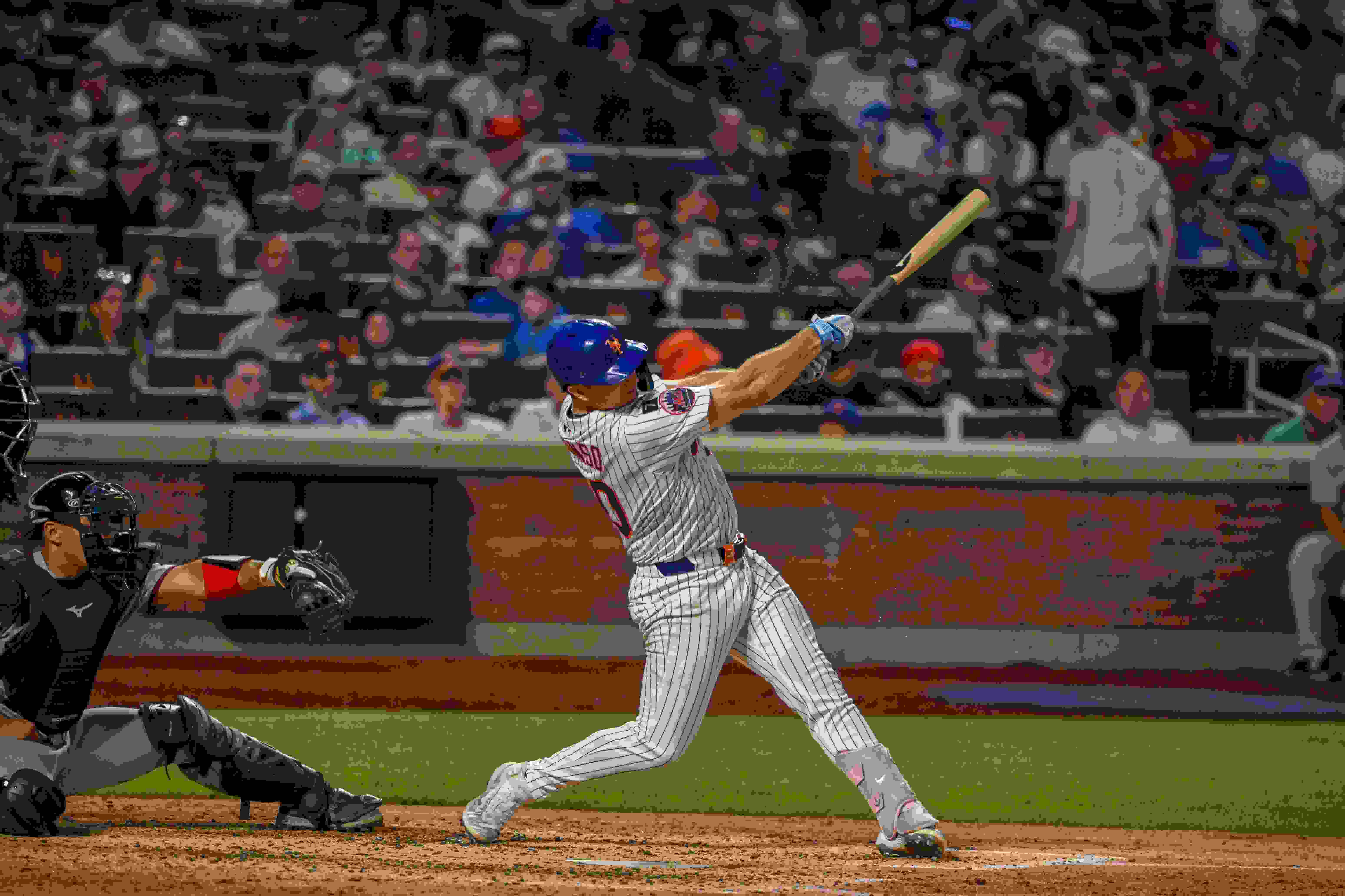 A photograph of a baseball player swinging his bat at the plate.