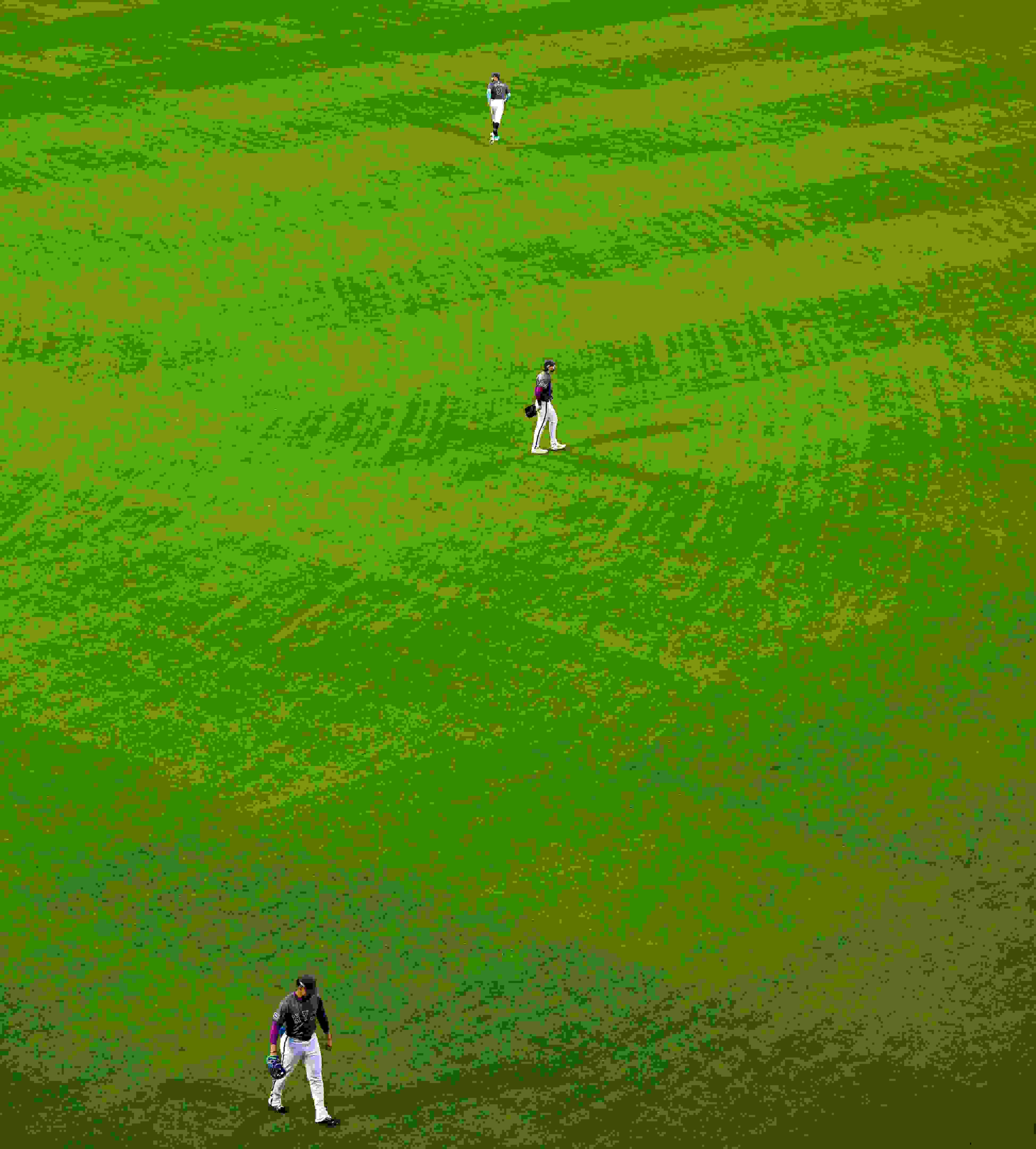 An overhead photograph of three New York Mets players arrayed in the outfield.