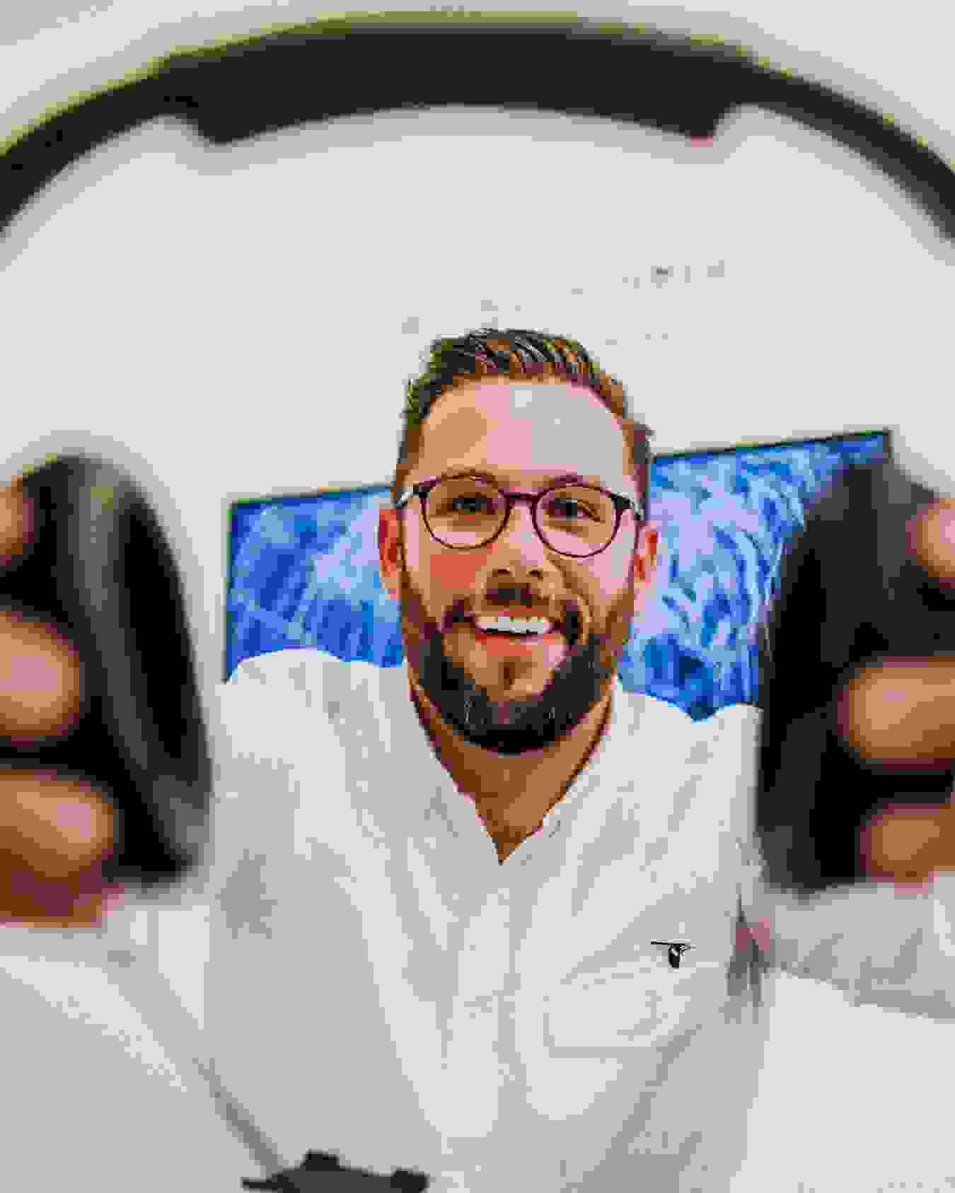 Student offering headphones to viewer