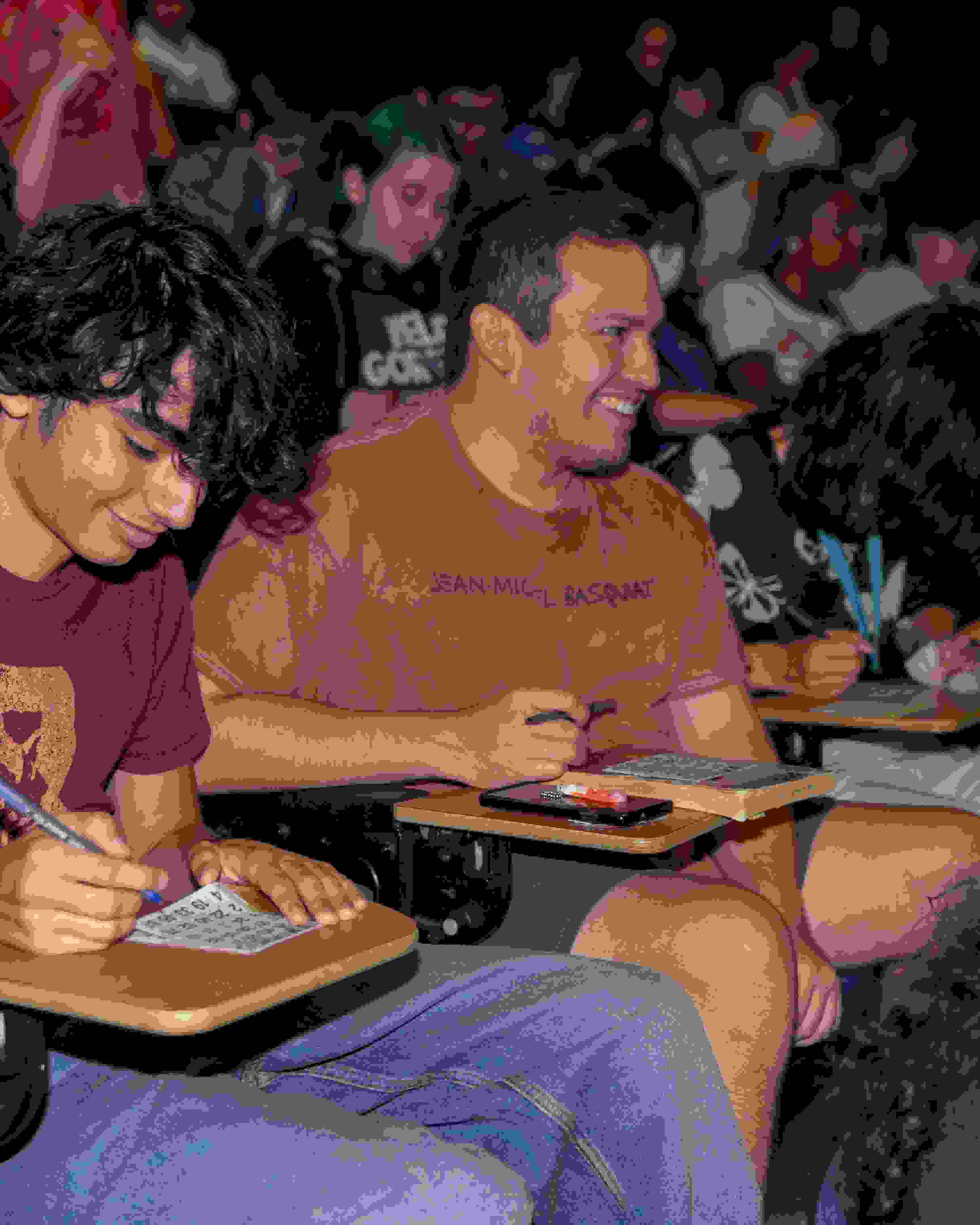 Rows of students sitting in the SVA Amphitheater playing Drag Queen Bingo.