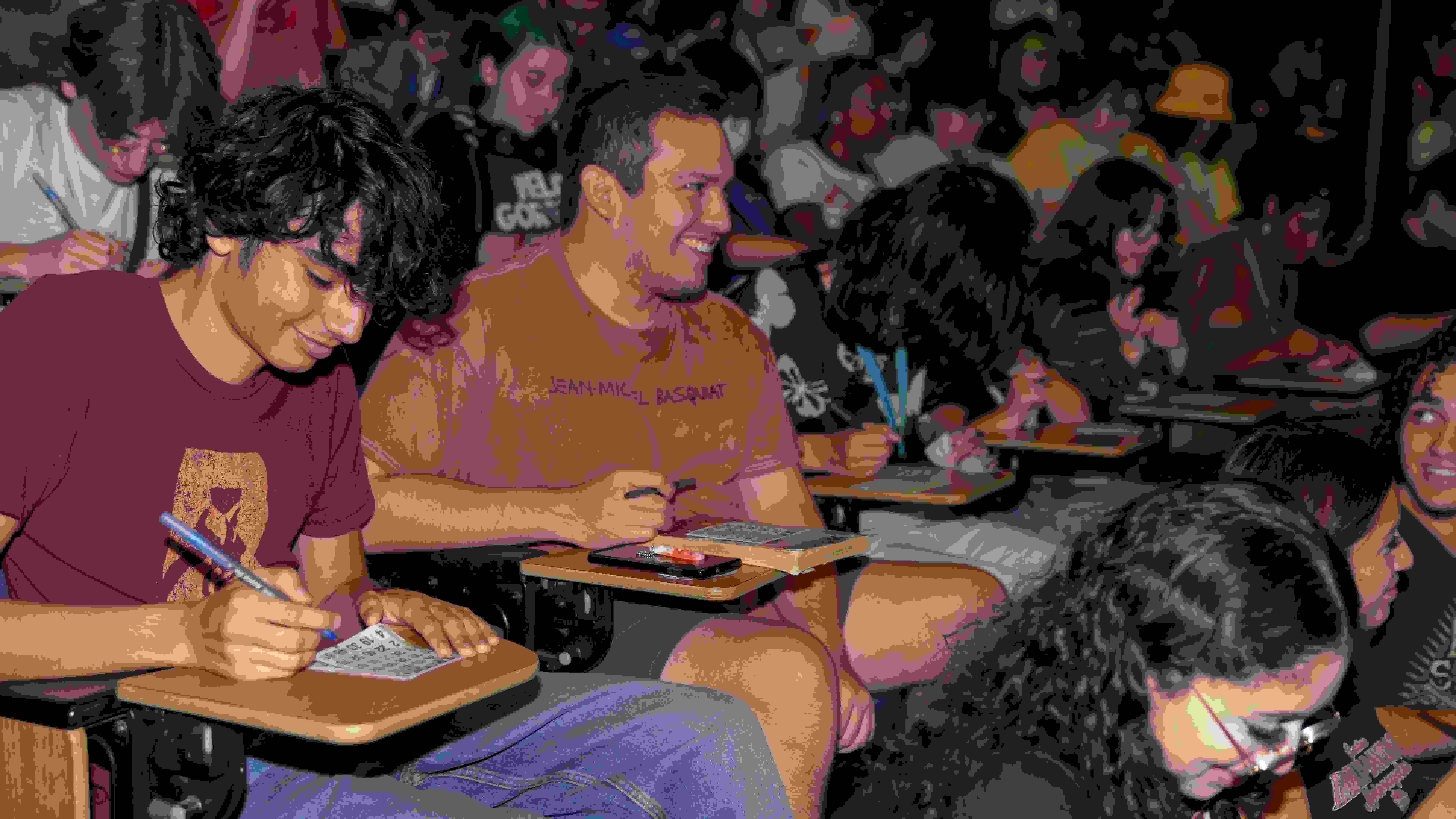 Rows of students sitting in the SVA Amphitheater playing Drag Queen Bingo.