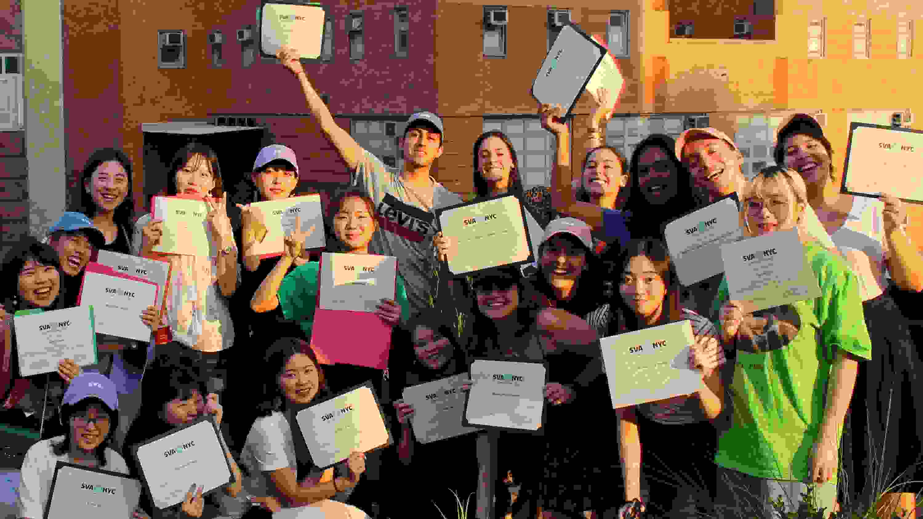 Students pose for a photo on a terrace, each with a certificate of course completion in their hand.