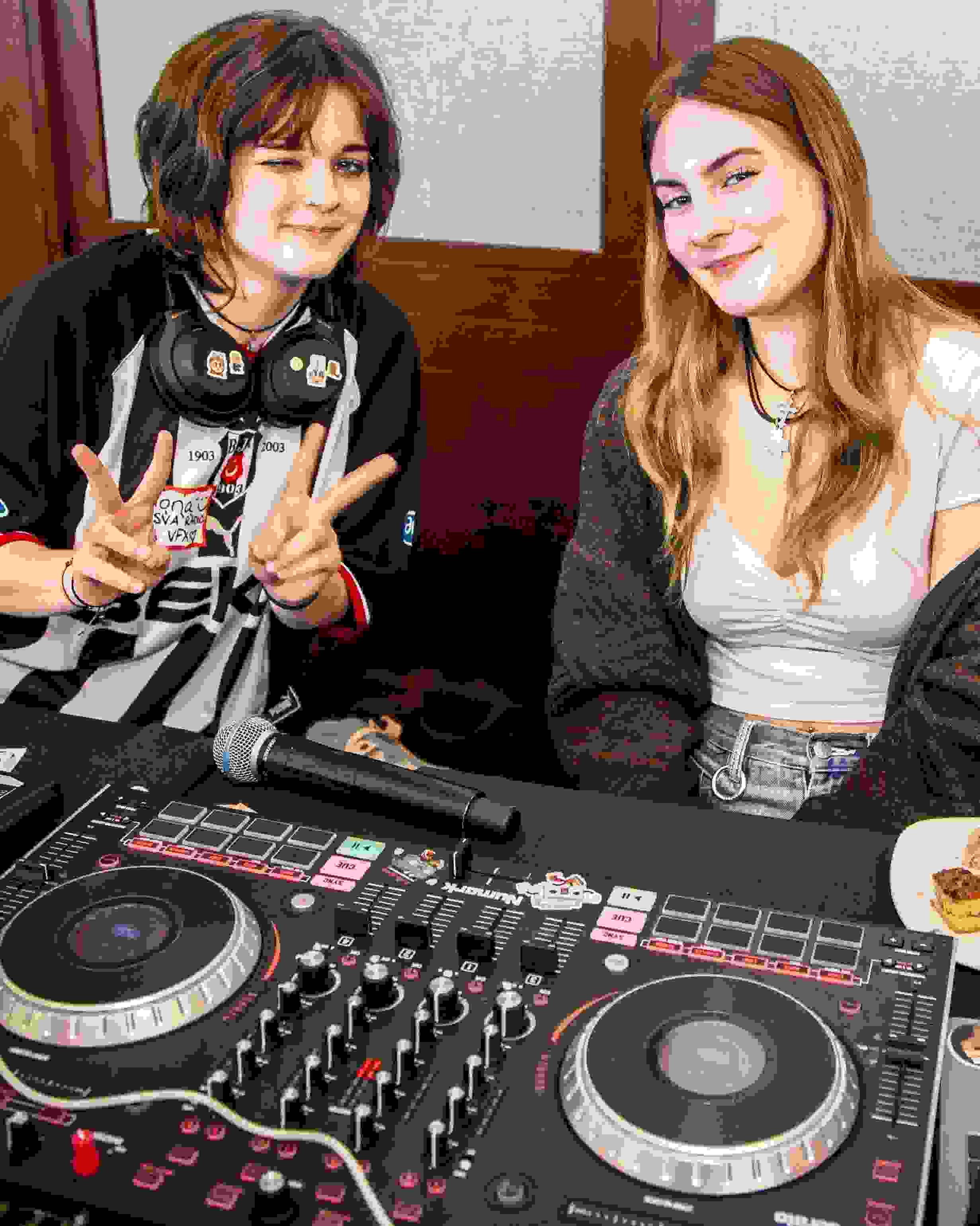 Two people at a club fair pose for a photo with a turntable and sign that says “WSVA.”