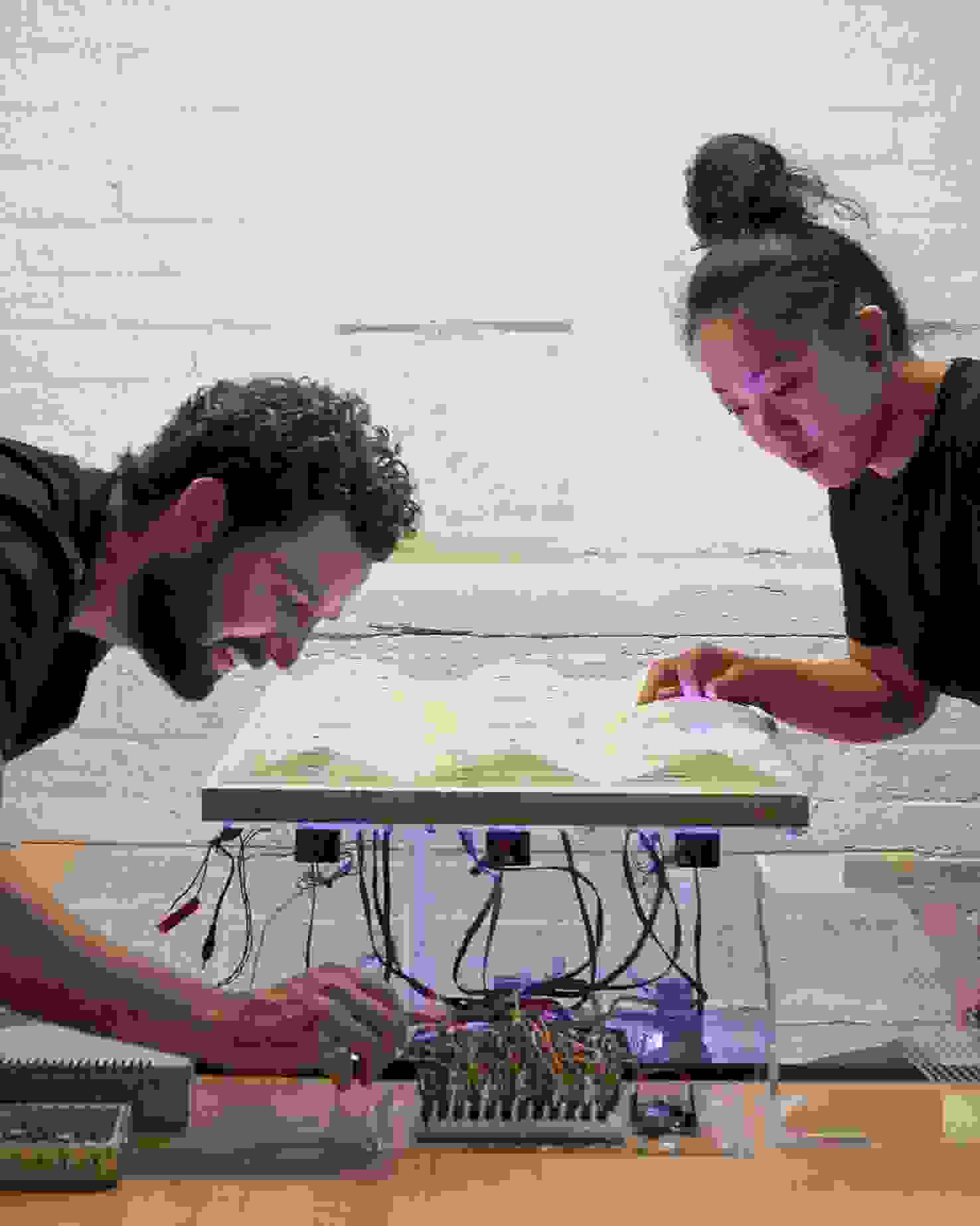 Students wiring an electronic illuminated art piece