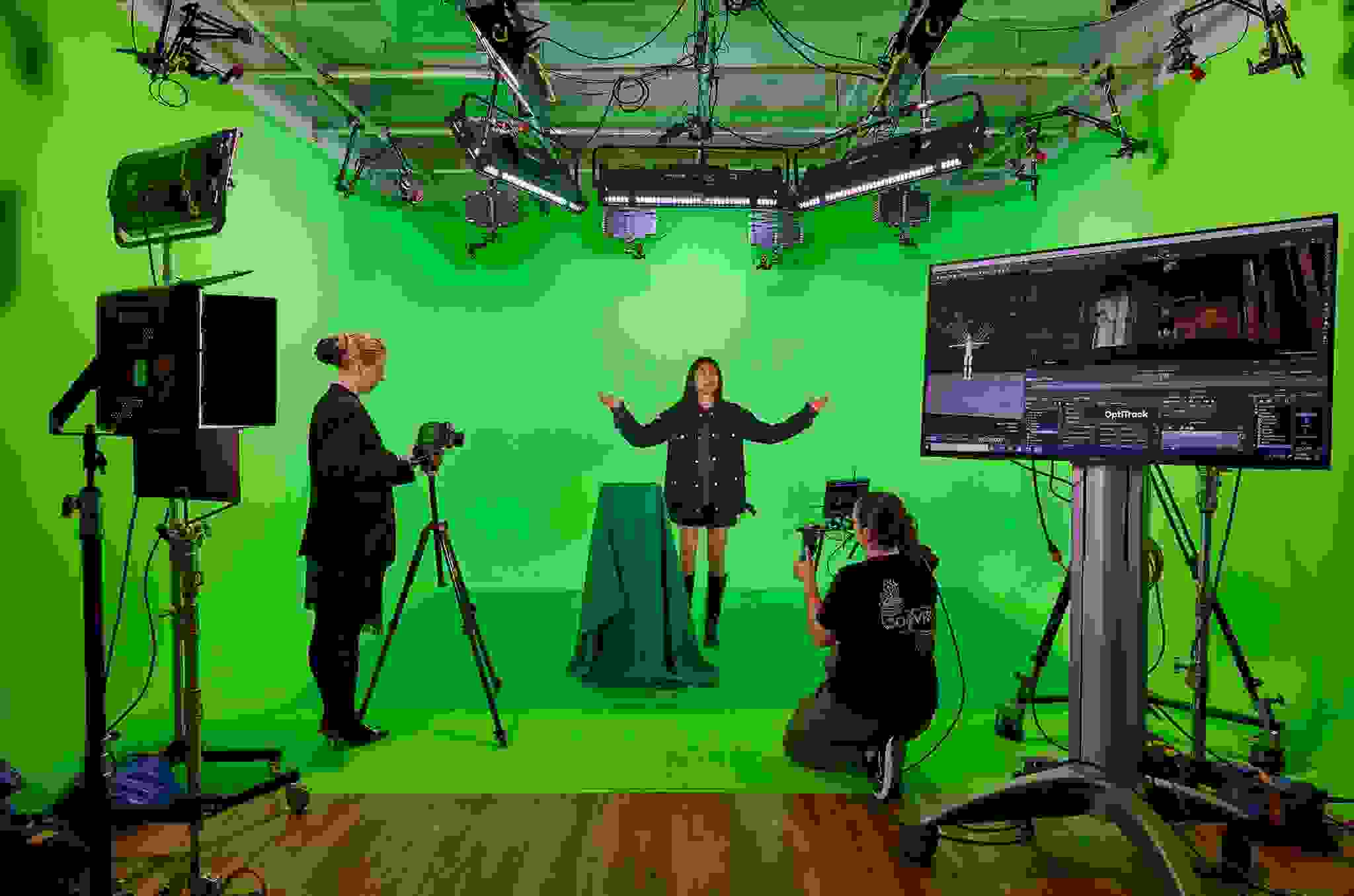 three people in front of a green screen with cameras and motion capture equipment