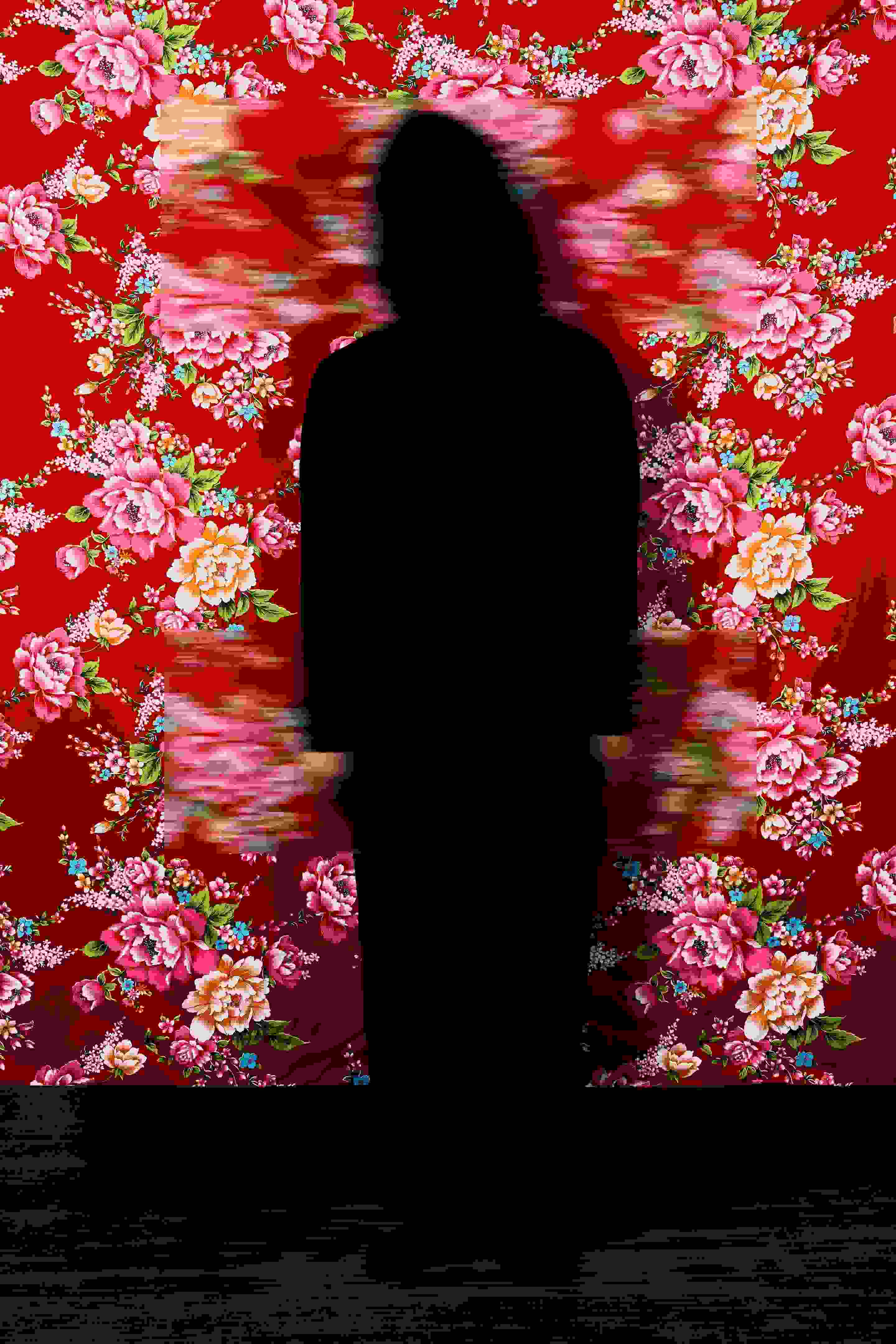 A black silhouette stands in front of a bright red floral wallpaper with two rectangular patches blurred.