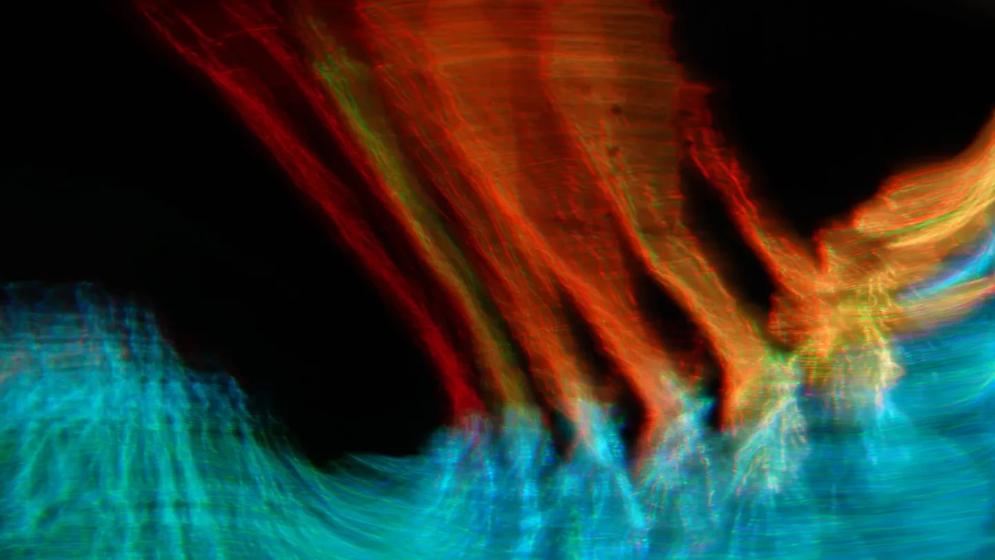 a visualization of light in waves of blue and red on a black background 