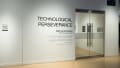 In the gallery alcove, outside of the glass doors, the wall text reads “Technological Perseverance / 2025 Fall Exhibition / MFA Computer Arts.”