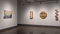 A corner of the first gallery with several mixed media artworks hung on the wall.