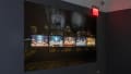 A wall depicting a large banner and five screens depicting AI-generated images.