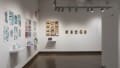 In the right corner of the space, five projects are displayed on the wall side by side. Some projects are presented with pinned prints and books, while others use small sculptures.