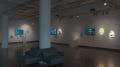 Several monitors on the walls play animated videos in gallery one of the SVA Chelsea Gallery. Each monitor is accompanied by prints and objects, such as small sculptures or dioramas. 