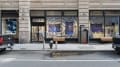 From outside the SVA Flatrion Gallery building, several works on fabric hang in the windows. One appears to be a quilt, while the other three are blurry photos printed on fabric. Behind them, many papers are arranged into circles radiating from the center point of the wall.
