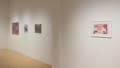 A lone print depicting a woman dressed as a geisha hangs on one wall. Further down the wall, there are three paintings of food and food stores.