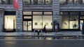 From outside of the gallery, the SVA Flatiron Windows show a wall of photographs depicting moments of daily life. One person walks by.
