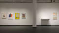 Chermayeff’s commercial works hang to the left of a wall-mounted vitrine and the landscapes made of dots.