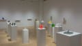 Colorful 3D printed sculptures displayed on standing pedestals and wall mounted ledges in the gallery space.