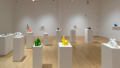 Many colorful 3D printed sculptures displayed on standing pedestals and wall mounted shelves throughout the gallery. 