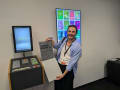 A man stands in front of an interactive installation holding an award