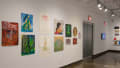 Multiple views of SVA Chelsea Gallery. There is illustrations and paintings hung on the walls. There are multiple shelves throughout the gallery with books places on them.