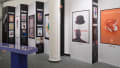 Gallery view of several vertical panels in a jagged, offset configuration, showing Milton Glaser's subway posters created for SVA from one perspective, and informational decade details on the other.